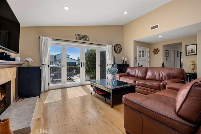 living area featuring recessed lighting, visible vents, a fireplace, and light wood finished floors