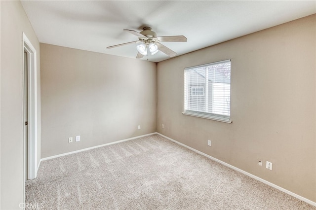 unfurnished room with a ceiling fan, carpet, and baseboards