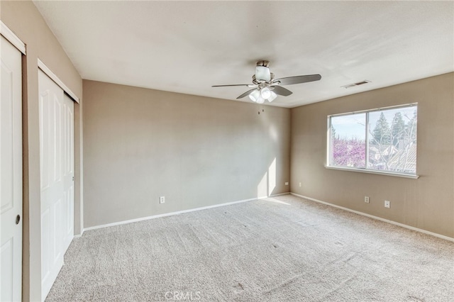 unfurnished bedroom with carpet flooring, baseboards, visible vents, and ceiling fan