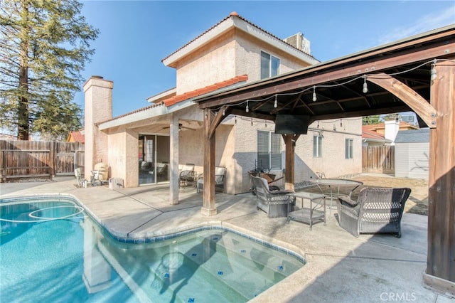 back of house featuring a patio area, a fenced in pool, a chimney, and fence