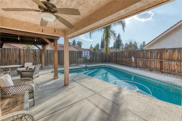 view of swimming pool featuring a fenced backyard, a fenced in pool, a ceiling fan, and a patio