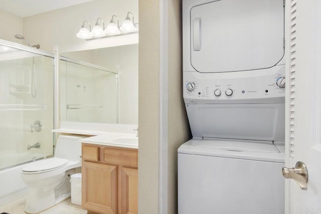 washroom with a sink, stacked washer and clothes dryer, and laundry area