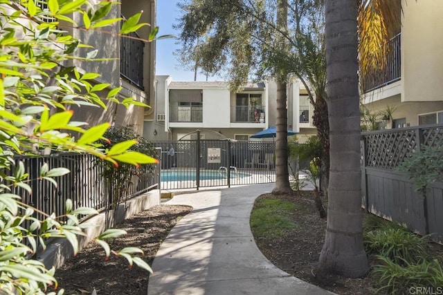 view of property's community with a swimming pool and fence