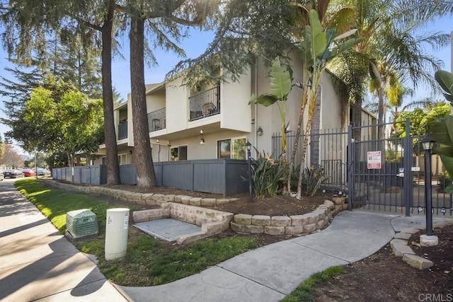 exterior space featuring stucco siding, fence, and a gate