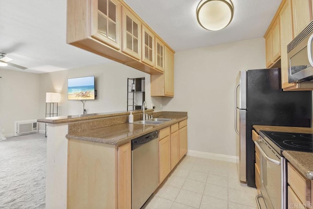 kitchen featuring light brown cabinets, appliances with stainless steel finishes, a peninsula, a ceiling fan, and a sink