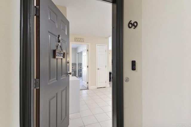 corridor featuring light tile patterned floors and baseboards