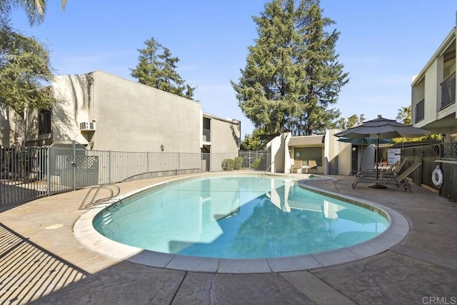 community pool with a patio and fence