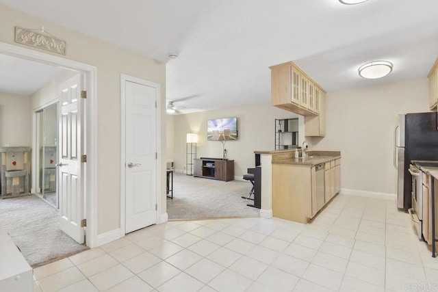 kitchen with glass insert cabinets, ceiling fan, light brown cabinetry, open floor plan, and light carpet