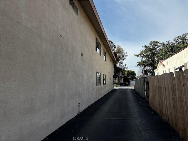 view of home's exterior with stucco siding and fence