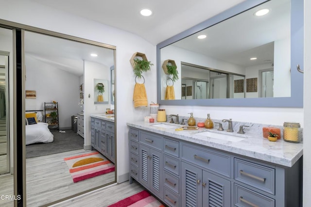 full bath with recessed lighting, vanity, and wood finished floors