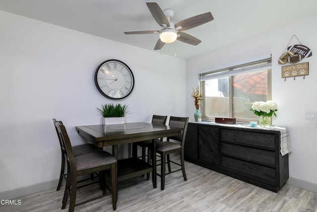 dining space with light wood-type flooring, baseboards, and ceiling fan