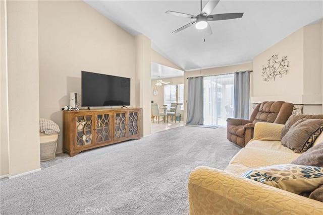 living area featuring vaulted ceiling, baseboards, ceiling fan, and carpet floors