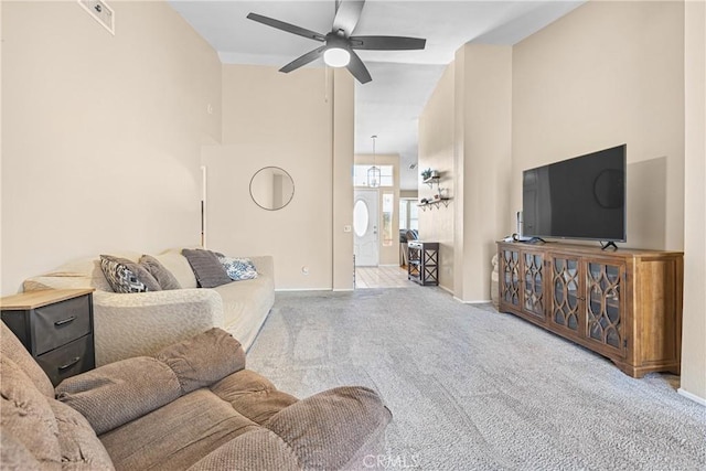 living room with a ceiling fan, carpet, visible vents, baseboards, and a high ceiling