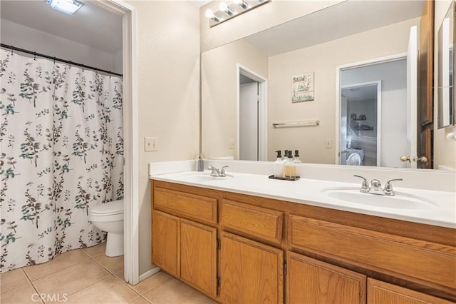 full bath featuring a sink, toilet, double vanity, and tile patterned flooring