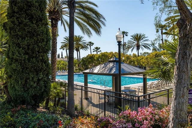 pool featuring a gazebo, fence, and a patio