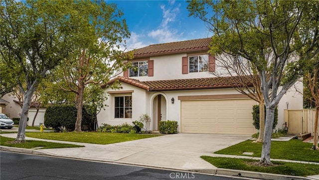 mediterranean / spanish house featuring a tile roof, a front yard, stucco siding, a garage, and driveway