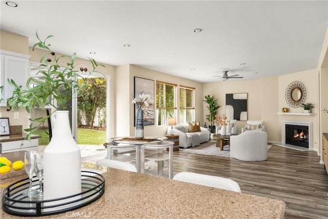 living area featuring recessed lighting, a fireplace with flush hearth, wood finished floors, and a ceiling fan