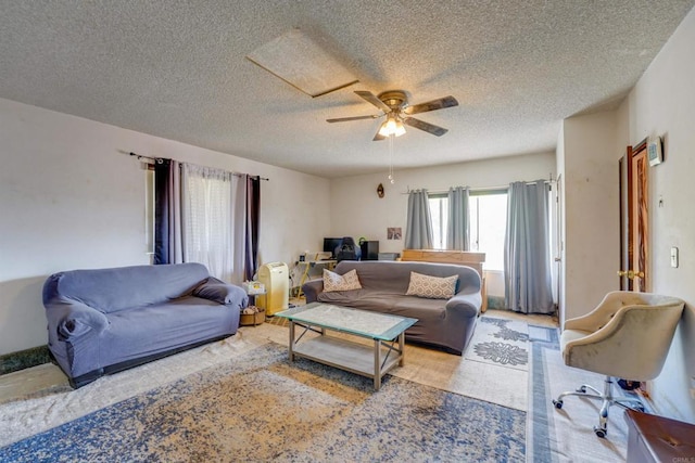 living room with a textured ceiling and ceiling fan