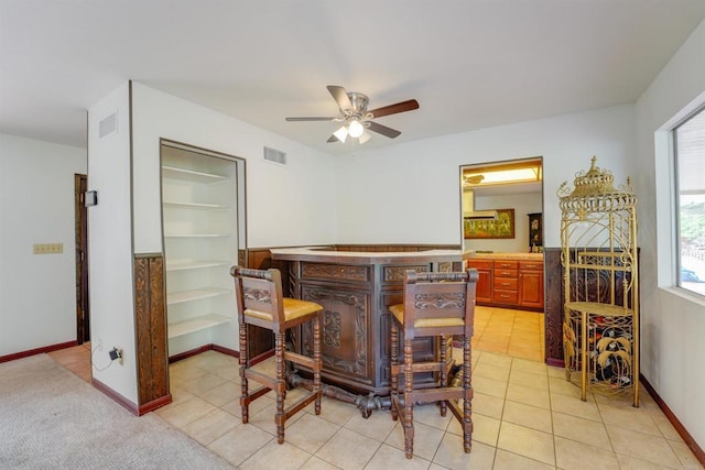 dining space featuring light tile patterned floors, visible vents, a dry bar, and built in features