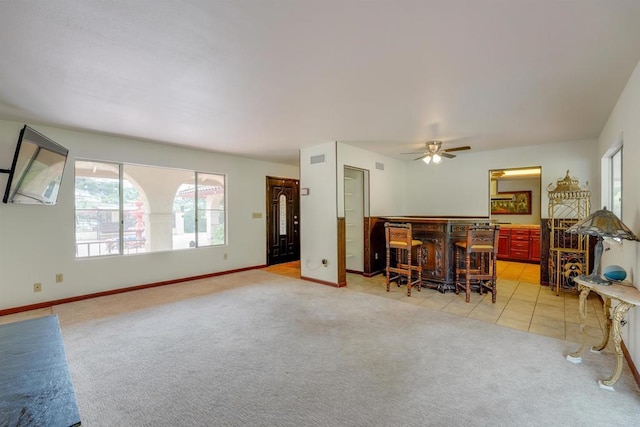 dining room with a dry bar, light colored carpet, visible vents, and baseboards