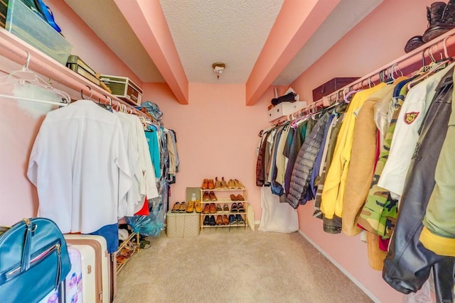 spacious closet with beam ceiling and carpet floors