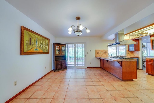 kitchen featuring decorative backsplash, baseboards, a peninsula, and a breakfast bar area