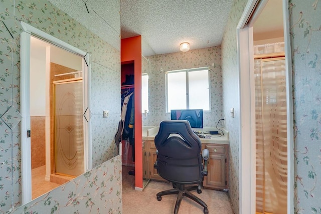 office area with a textured ceiling and wallpapered walls