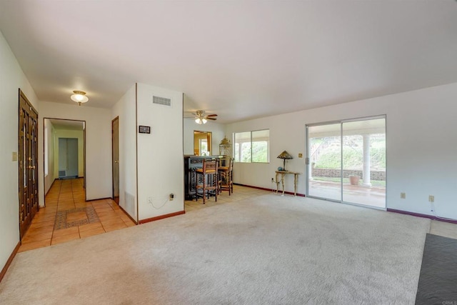 unfurnished living room featuring visible vents, baseboards, a ceiling fan, and carpet flooring