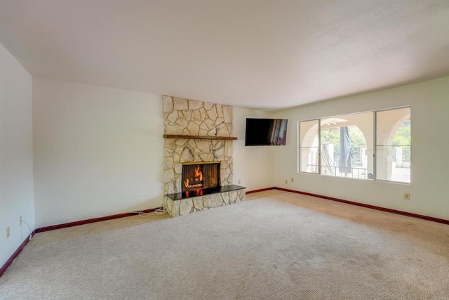 unfurnished living room featuring baseboards, carpet floors, and a fireplace