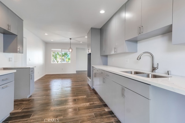 kitchen featuring recessed lighting, gray cabinets, dark wood-style flooring, and a sink