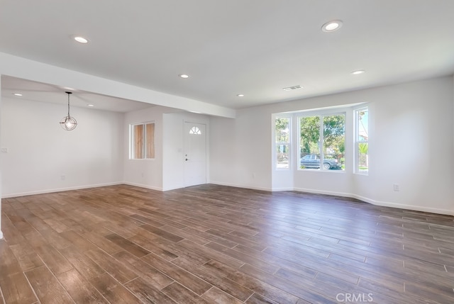 unfurnished living room featuring recessed lighting, visible vents, baseboards, and dark wood-style floors