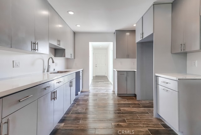 kitchen featuring a sink, wood tiled floor, gray cabinets, and light countertops