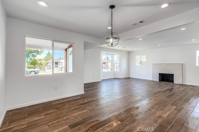 unfurnished living room featuring a tiled fireplace, baseboards, visible vents, and dark wood-style flooring