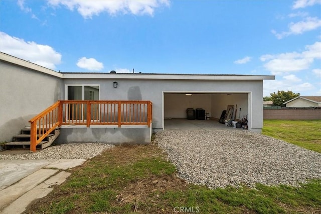 rear view of house with a garage and fence