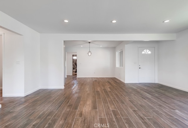 unfurnished living room featuring recessed lighting, baseboards, and dark wood-style flooring