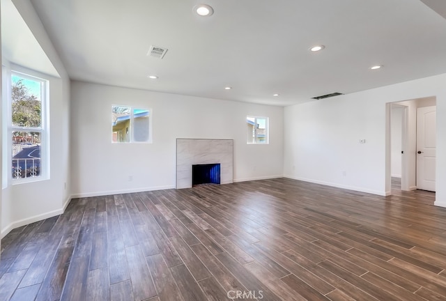 unfurnished living room with baseboards, visible vents, recessed lighting, a tile fireplace, and dark wood-type flooring