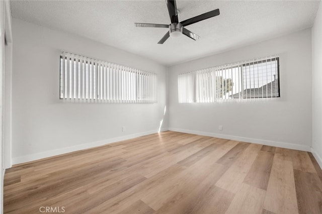 unfurnished room featuring light wood-style flooring, a textured ceiling, baseboards, and ceiling fan