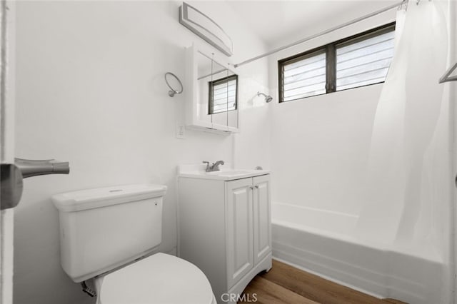 bathroom featuring vanity, toilet, wood finished floors, and shower / bath combo with shower curtain