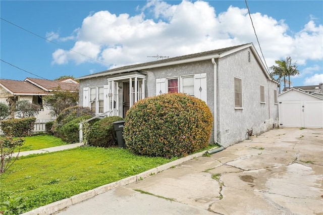 view of front of house featuring stucco siding and a front yard