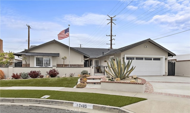 view of front facade with stucco siding, driveway, a gate, a fenced front yard, and an attached garage