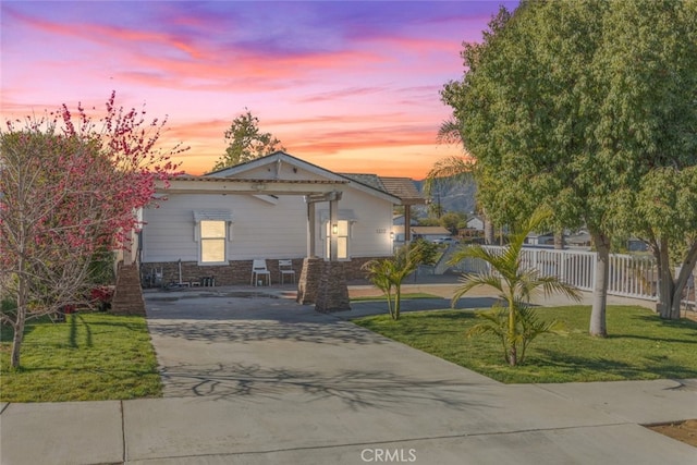 view of front of property with driveway, a yard, and fence