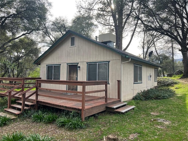 back of property featuring a yard and a deck