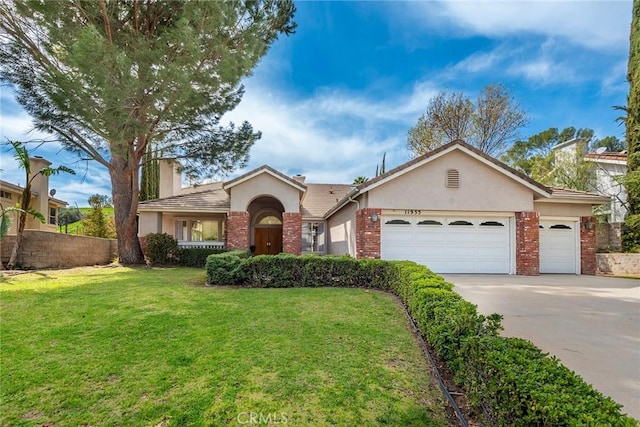 ranch-style home featuring stucco siding, driveway, a front lawn, a garage, and brick siding