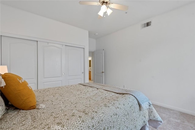 carpeted bedroom featuring a closet, visible vents, ceiling fan, and baseboards