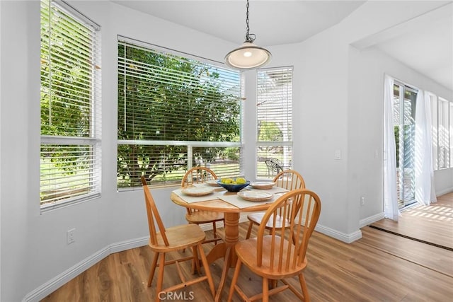 dining space featuring wood finished floors and baseboards