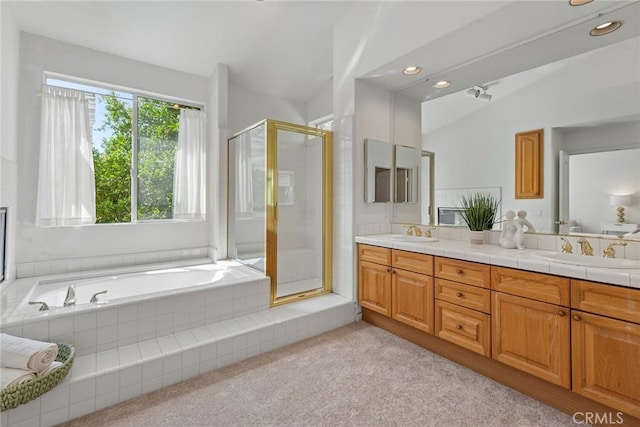 bathroom with a shower stall, a bath, double vanity, and a sink