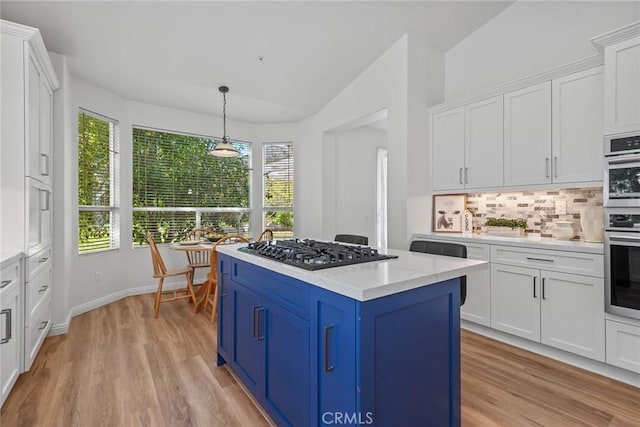 kitchen featuring blue cabinetry, gas cooktop, white cabinets, light countertops, and a healthy amount of sunlight