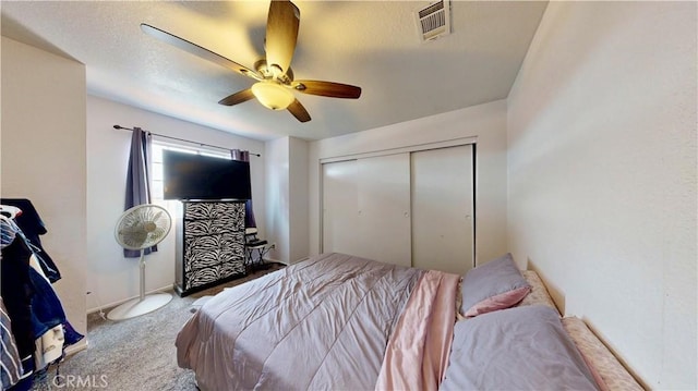 carpeted bedroom featuring a closet, visible vents, and ceiling fan