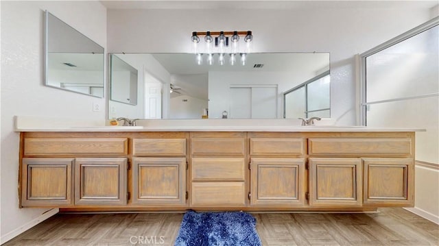 bathroom featuring double vanity, baseboards, and a sink