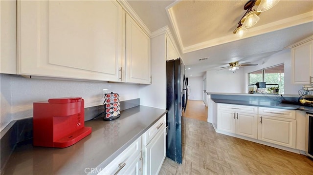 kitchen featuring visible vents, a ceiling fan, dark countertops, white cabinetry, and freestanding refrigerator